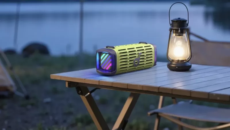 Колонка Anker Soundcore Boom 3i лежит вечером на столе со включенной подсветкой