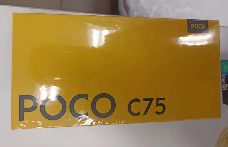 Новая, запечатанная в пленку, желтая коробка смартфона POCO C75 с названием модели, написанным крупным темным шрифтом.