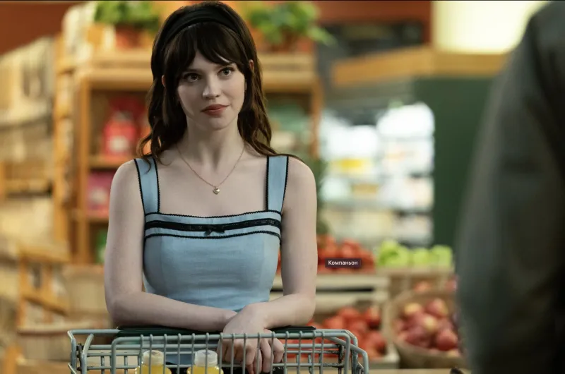 Героиня сидит за обеденным столом с напряженным выражением лица