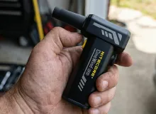 Использование Nitecore CW20 в гараже: мужская рука держит мощный воздушный вентилятор с насадкой-соплом для продувки.